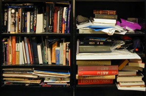 A messy bookshelf with lots of books