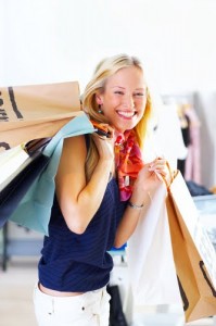 Smiling woman holding many shopping bags